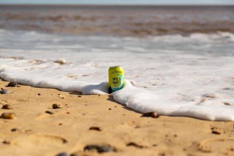 Can of beer from Adnams Southwold brewery on a beach