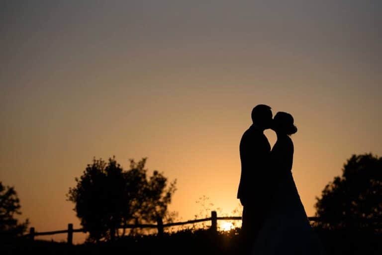 A happy couple kissing at sunset
