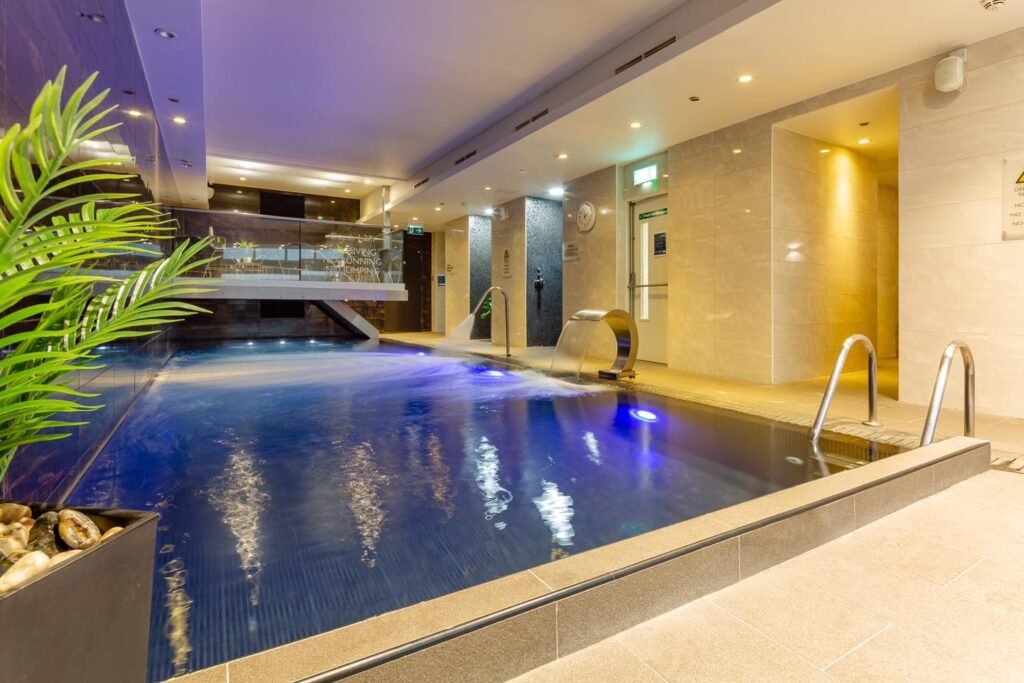 Modern interior swimming pool with shower and fountain.